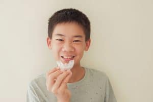Invisalign In Charlotte, Nc 1 Bigstock Smiling Asian Preteen Boy Hold 412484362